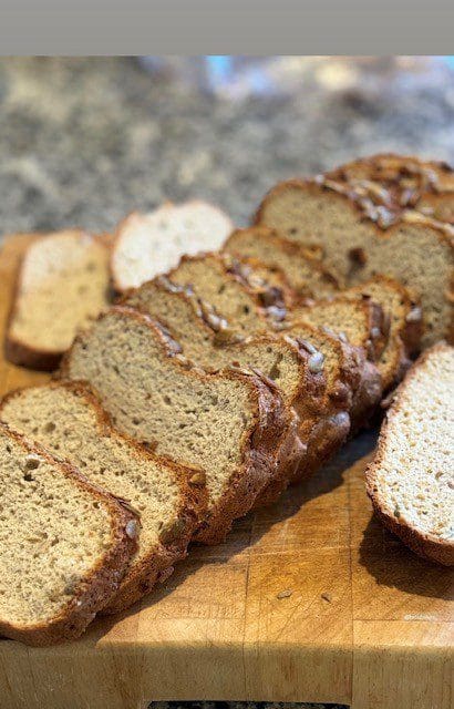 Sliced loaf of homemade bread on a wooden board.