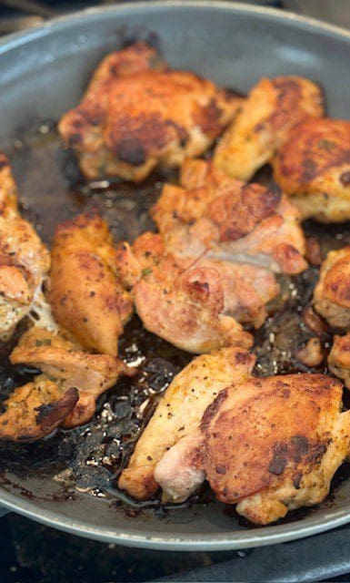 Grilled chicken pieces cooking on a barbecue grill.